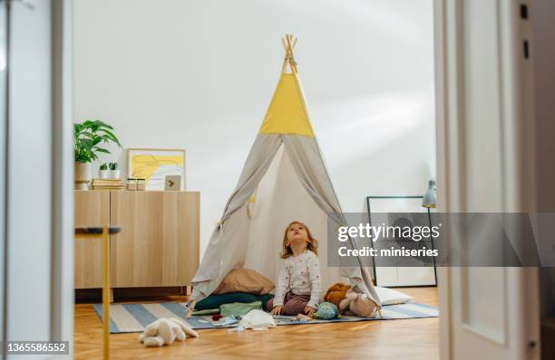 adorable girl playing in the teepee tent at home - wigwam stockfoto's en -beelden