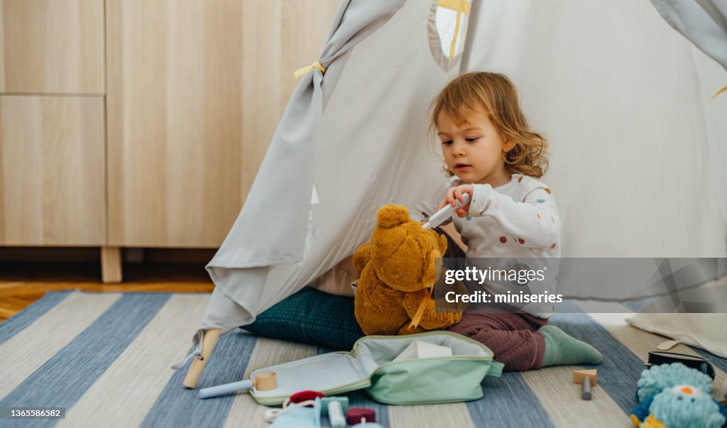Adorable Girl Sitting on the Floor and Playing at Home