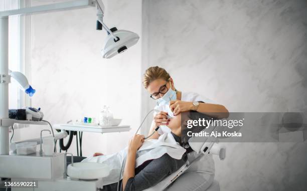 dentist removing dental calculus. - dental hygienist stock pictures, royalty-free photos & images