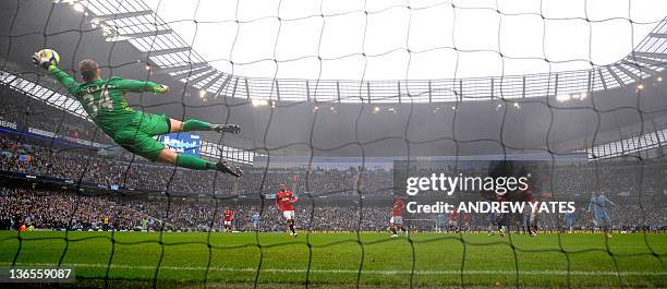 Manchester United's Danish goalkeeper Anders Lindegaard saves a shot from Manchester City's Argentinian forward Sergio Aguero during the FA Cup third...