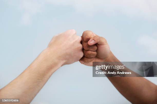 fist bump greeting - rivalidad fotografías e imágenes de stock