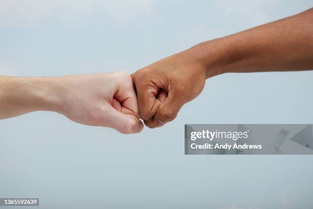 fist bump greeting - fist bump fotografías e imágenes de stock