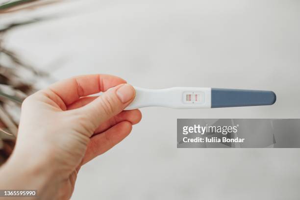 pregnancy test in woman's hand - pregnancy test stock pictures, royalty-free photos & images