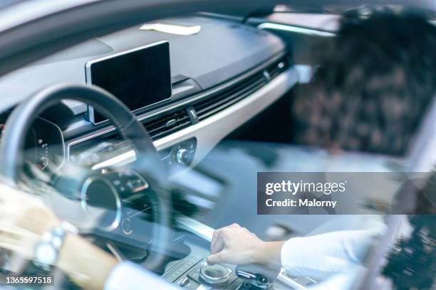 young woman driving a car. close-up of the dashboard. - autonome technologie stock-fotos und bilder