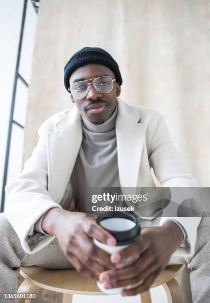 elegant young man wearing white winter coat - eyeglasses winter stock pictures, royalty-free photos & images