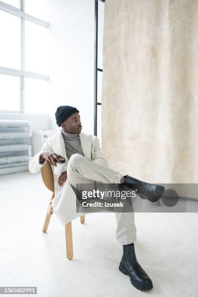 elegant young man wearing white winter coat - black boot bildbanksfoton och bilder