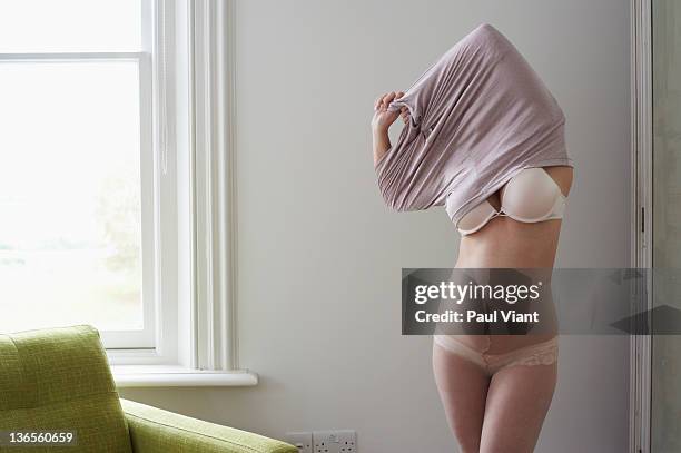 woman undressing showing underwear - uitkleden stockfoto's en -beelden