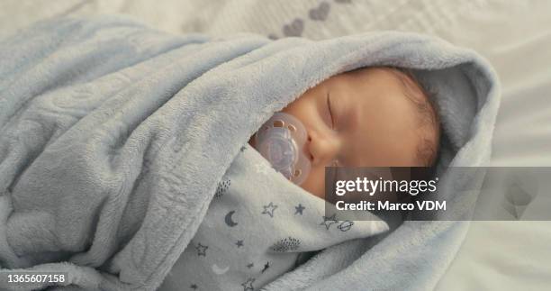 shot of a newborn baby boy sleeping - wrapped in a blanket stockfoto's en -beelden