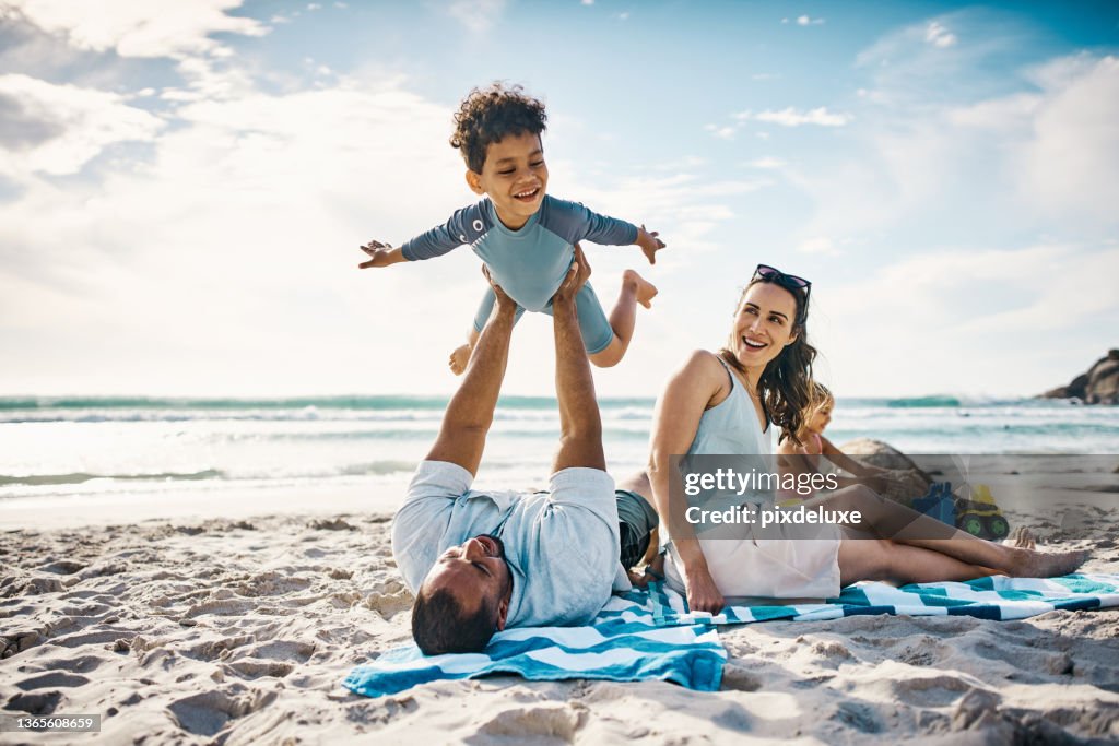 Shot of a man playing with his son on the beach