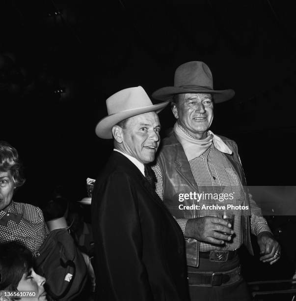American actor and singer Frank Sinatra with actor John Wayne at a SHARE Boomtown benefit party, USA, 1965.