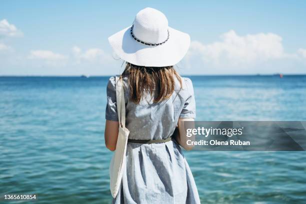 young woman in wide brim hat on the seashore. - hot women on boats ストックフォトと画像