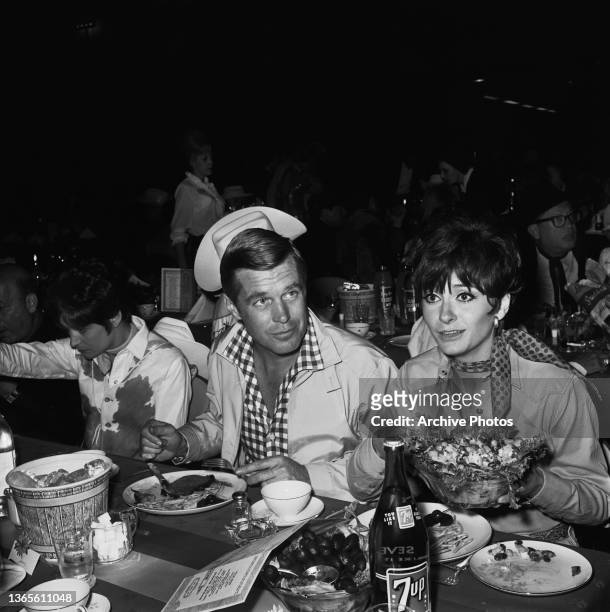 American actor George Peppard and his partner, actress Elizabeth Ashley at a SHARE Boomtown benefit party, USA, 1965.