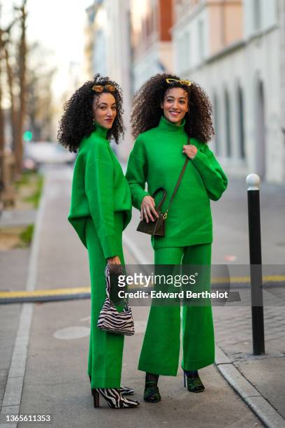 Guest wears green sunglasses, a green ribbed turtleneck oversized pullover, matching green flared pants, a white and black zebra print pattern...