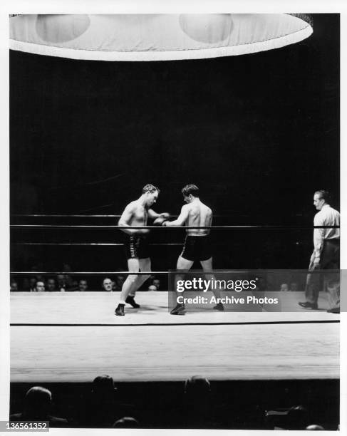 William Gargan and Robert Taylor have boxing match with Larry McGrath as referee in a scene from the film 'The Crowd Roars', 1938.