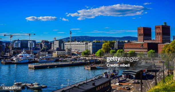 city of oslo wharf and waterfront with view of city hall - oslo norway - oslo city hall stock-fotos und bilder