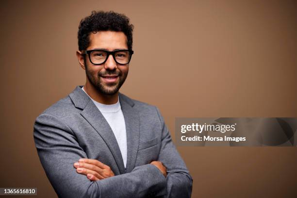 confident businessman against brown background - grå blazer bildbanksfoton och bilder