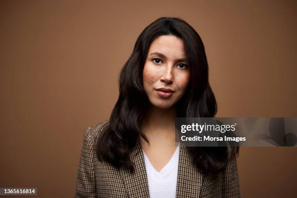 businesswoman against brown background - russian business woman stock-fotos und bilder