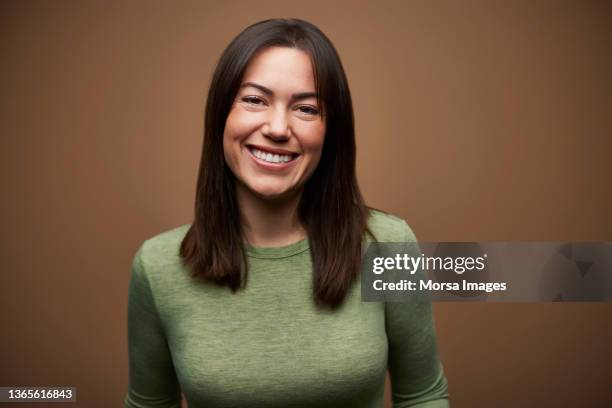 happy woman against brown background - generación del milenio fotografías e imágenes de stock