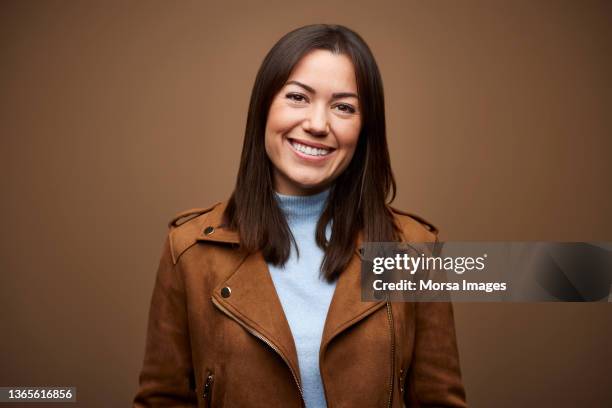 happy businesswoman wearing brown jacket - studio portraits stock pictures, royalty-free photos & images