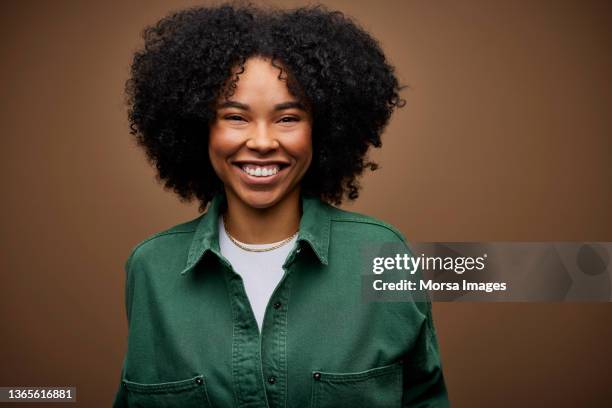 cheerful businesswoman against brown background - grünes hemd stock-fotos und bilder