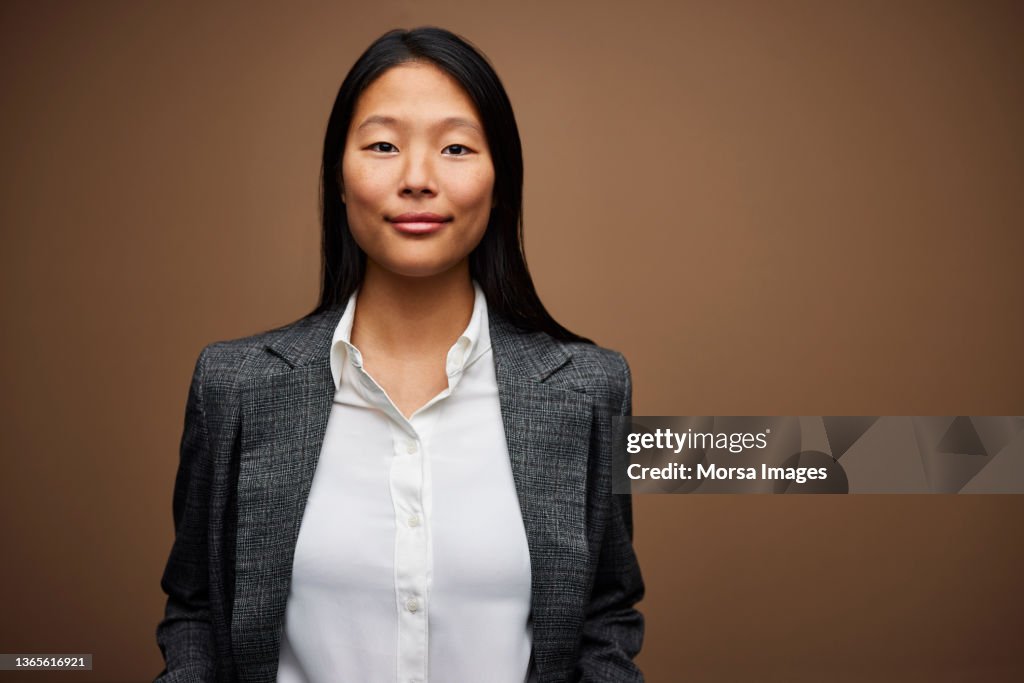 Young Businesswoman against Brown Background