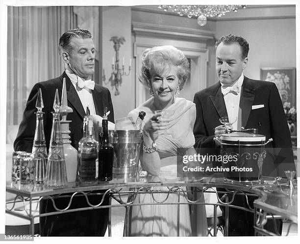 Michael St Angel, Marilyn Maxwell, and Ray Montgomery standing around the champagne in a scene from the film 'Critic's Choice', 1963.