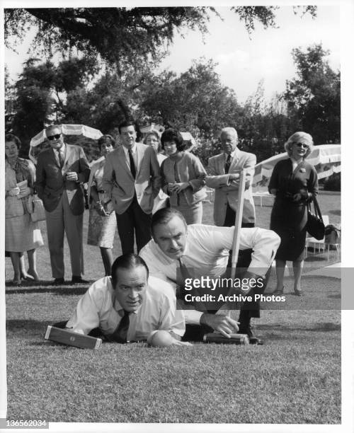 Bob Hope and John Dehner look over a croquet shot in a scene from the film 'Critic's Choice', 1963.