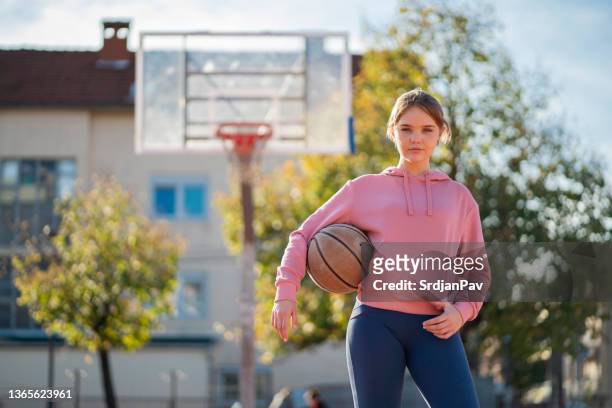 porträt eines aktiven kaukasischen teenagers auf dem basketballplatz im freien - basketball teenager stock-fotos und bilder