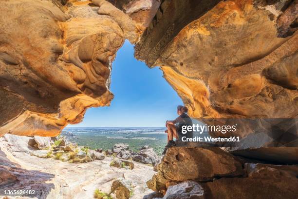 australia, victoria, female tourist relaxing inside hollow mountain cave in grampians national park - grampians stock pictures, royalty-free photos & images