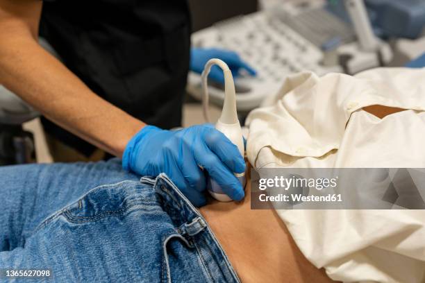 doctor performing ultrasound examination on patient stomach - ecografía fotografías e imágenes de stock