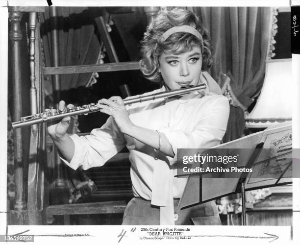 Glynis Johns playing the flute in a scene from the film 'Dear Brigitte', 1965.