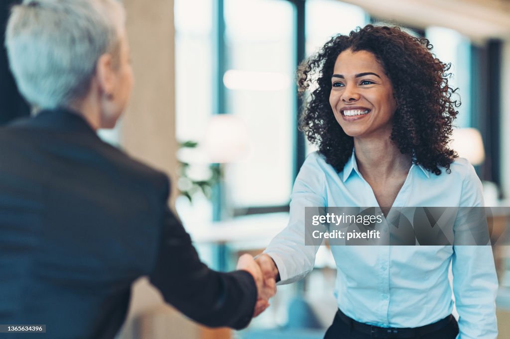 Smiling businesswoman greeting a colleague on a meeting