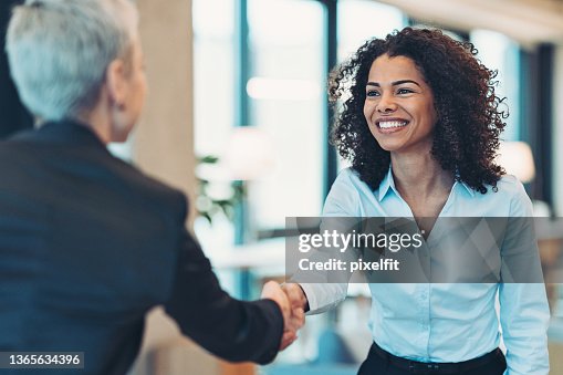 Smiling businesswoman greeting a colleague on a meeting Smiling businesswoman greeting a colleague on a meeting