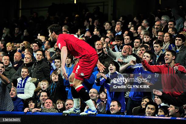 Portsmouth's English midfielder Joel Ward jumps up onto the advertising boards to stop himself running into the crowd during the English FA Cup third...