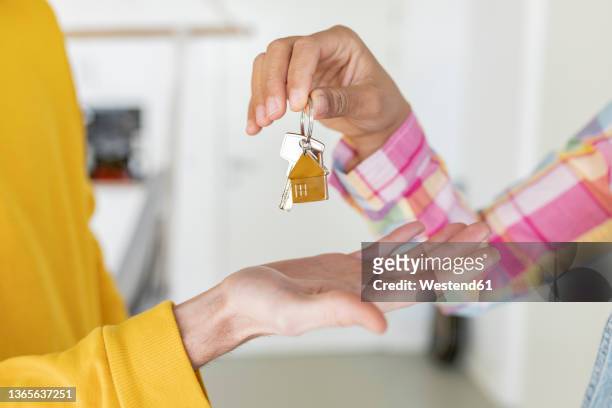 woman giving house key to man - house key hands stock pictures, royalty-free photos & images