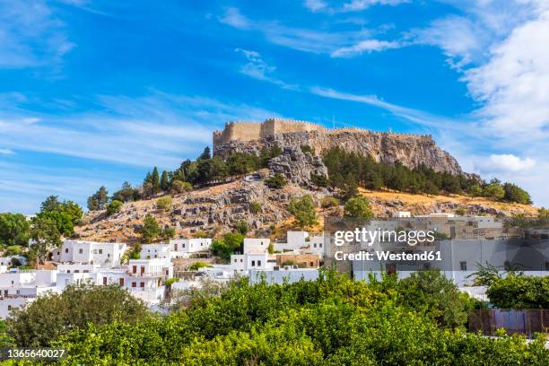 hill with acropolis near town of lindos on sunny day, rhodes, greece - insel rhodos inselgruppe dodekanes stock-fotos und bilder