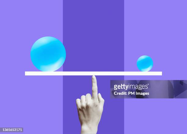 balanced on a black and white finger - weigh in stockfoto's en -beelden