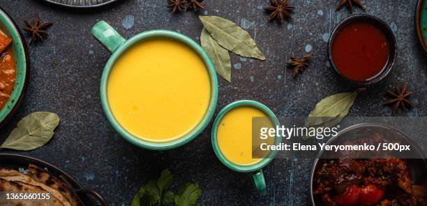 healthy indian ayurveda drink mango lassi in two cups on rustic - yellow smoothie stock pictures, royalty-free photos & images