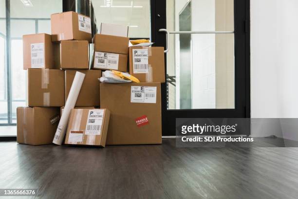 large stack of delivered packages in office - package stockfoto's en -beelden