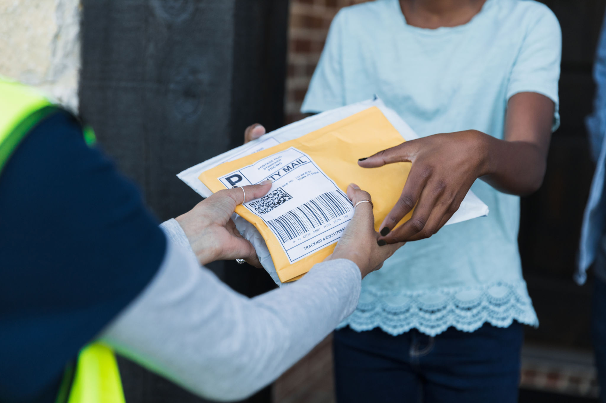 Focus on unrecognizable girl receiving packages from unrecognizable mail person Focus on unrecognizable girl receiving packages from unrecognizable mail person