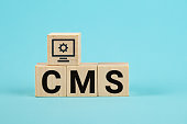 CMS acronym on woodblock cubes blue background, Frequently asked questions, Business customer service, and support concept. acronym CMS on wooden cubes Content Management System