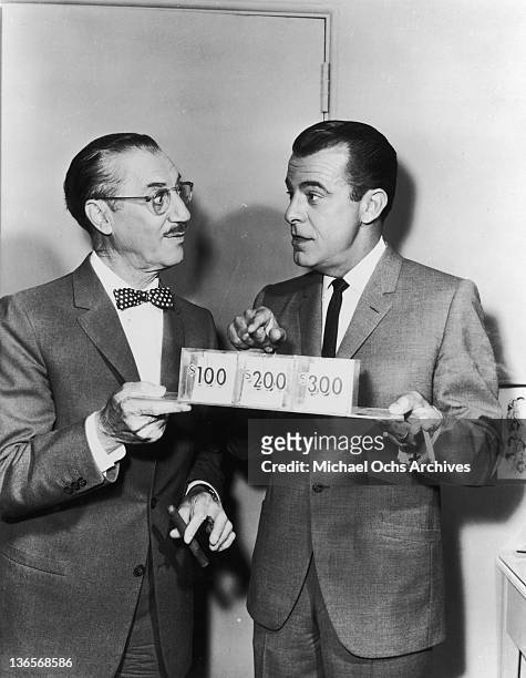 American comedian Groucho Marx with his co-host on the radio and television quiz show 'You Bet Your Life', George Fenneman , circa 1960. They are...