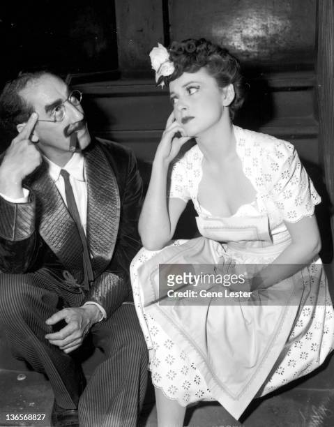 American comedian Groucho Marx with actress Olivia de Havilland during their tour with the Hollywood Victory Caravan, USA, 16th May 1942. The tour...