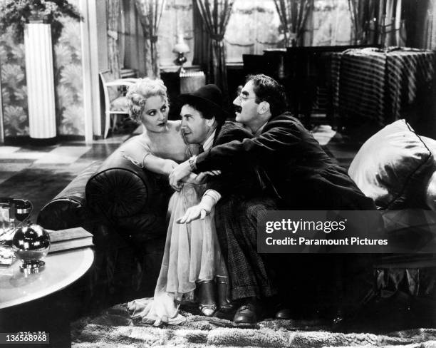 American comedian Groucho Marx and his brother Chico pay homage to the college widow, played by Thelma Todd , in a scene from 'Horse Feathers',...