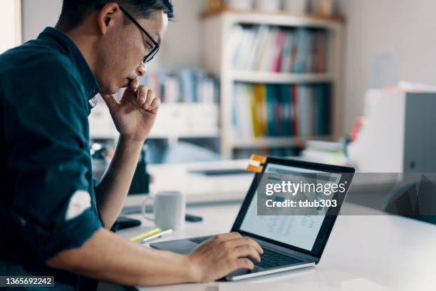 ein erwachsener mann, der in seiner schmuckwerkstatt an seinen persönlichen finanzen arbeitet - asian market stock-fotos und bilder