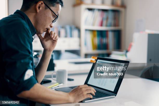 mid adult man working on his personal finance in his jewellery work shop - accounting stock pictures, royalty-free photos & images
