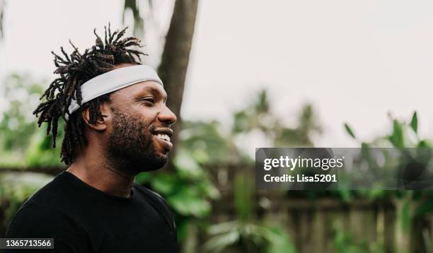 candid casual portrait of happy smiling black man outdoors with dreadlock hair - sweat band stock pictures, royalty-free photos & images