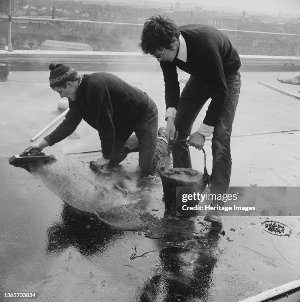 Doddington Estate, Battersea, Wandsworth, London, . Two workers asphalting the roof of a block of flats during the construction of the Doddington...