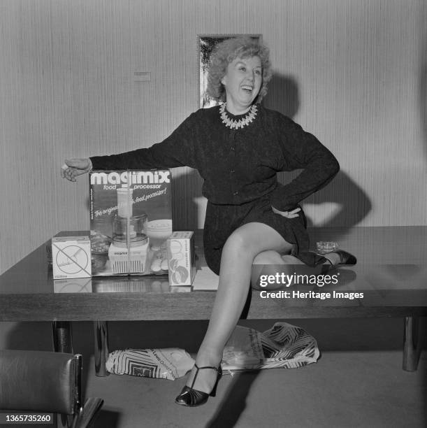 Regent Street, City of Westminster, London, . Laing retiree Anne Kidd posed sitting on a table beside her retirement gift of a Magimix food...