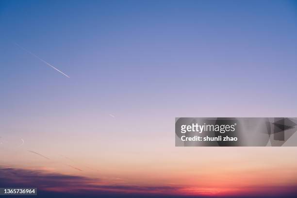 the gradient of the sky at sunset - sunset with jet contrails stock pictures, royalty-free photos & images